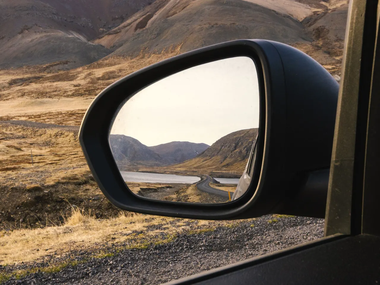 View of Road in Mountains Landscape in Car Side Mirror